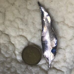 An oxidized silver feather pin/brooch. Handcrafted, delicate and elegant